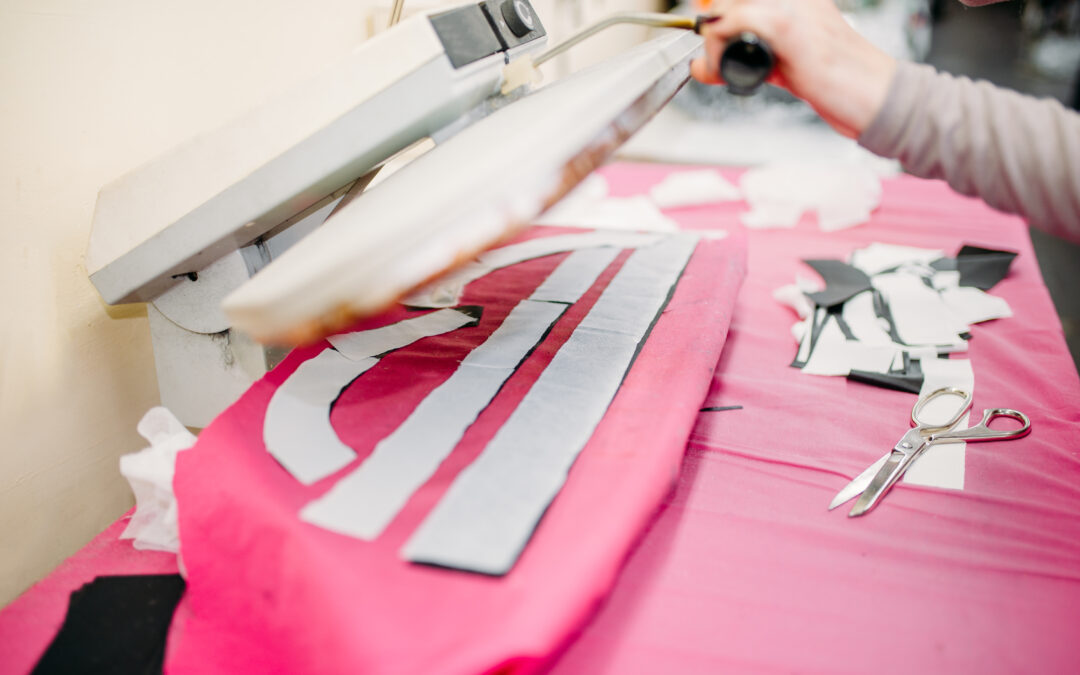 Clothes designer works on steam press